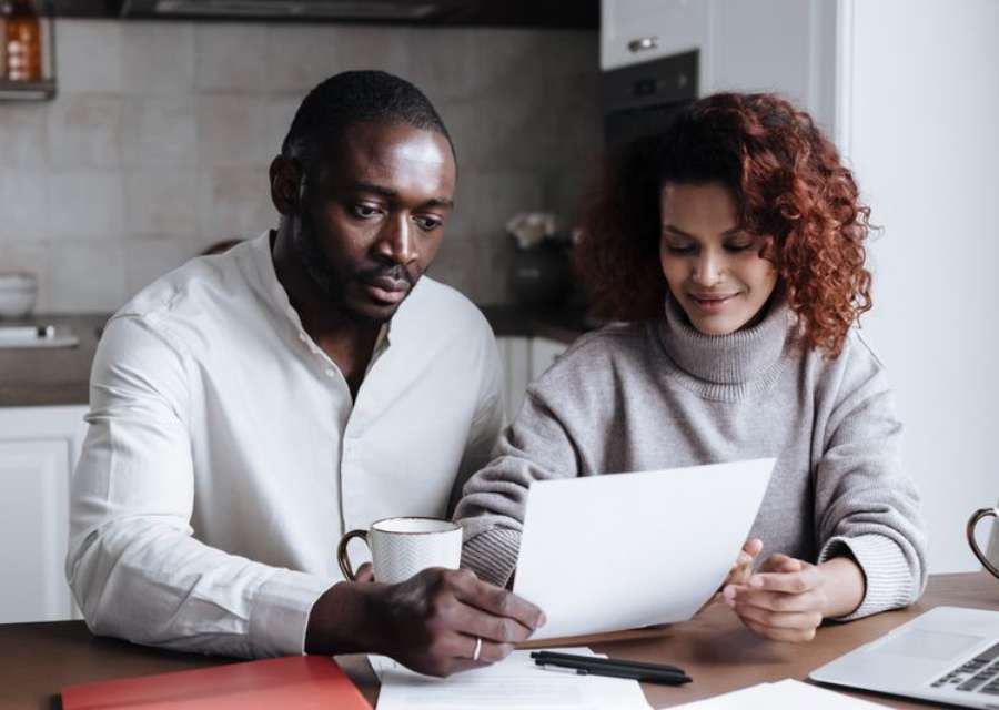 Couple examinant ses documents de prêt immobilier à la maison